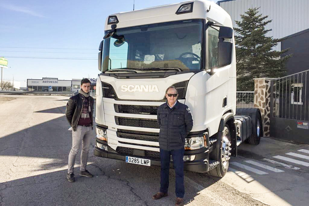 Los dos eslabones de la empresa posan junto a uno de sus camiones