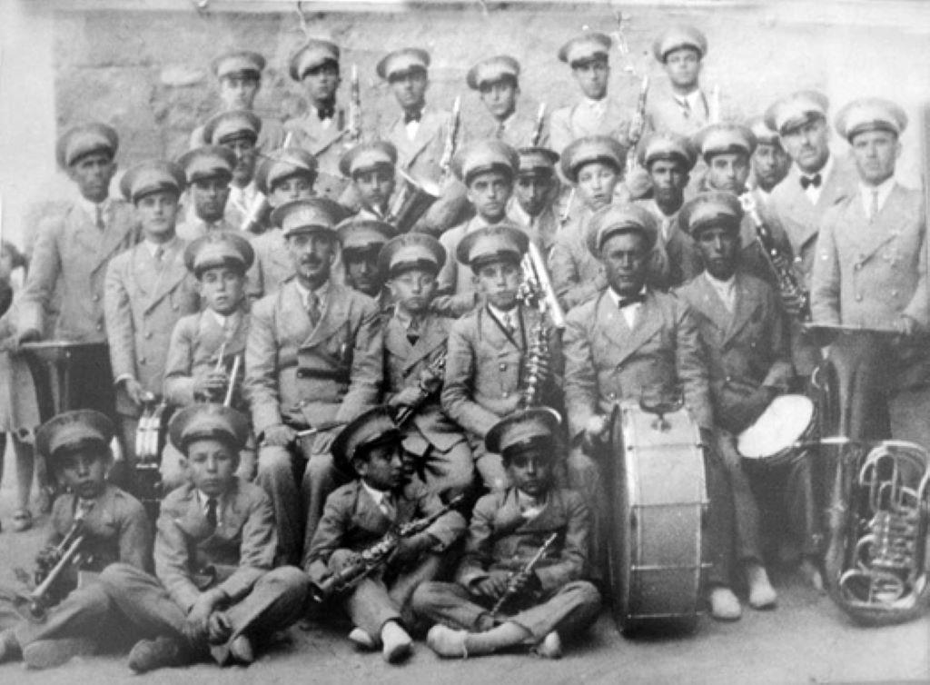  Principios de los años 30 del pasado siglo. Fotografía de la primera plantilla de la Banda Municipal de Música de Argamasilla de Alba.  En la segunda fila (sentado, segundo por la izquierda) su prime